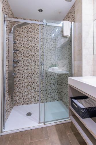 a shower with a glass door in a bathroom at San Anton, Ventana al mar in Llanes