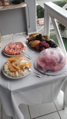a white table with plates of food on it at Pousada Flor de Lins in Piranhas