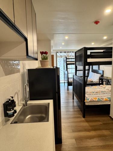 a kitchen with a sink and a bunk bed at Dee Condo Baguio in Baguio