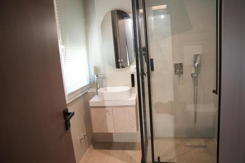 a bathroom with a glass shower and a sink at Hotel Aquila D in Durrës
