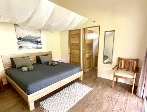 a bedroom with a bed and a chair at Paradiselodge - Casa Linda in Platanillo
