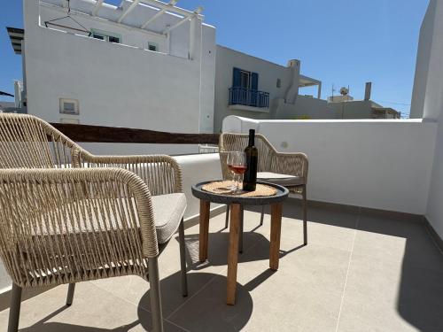 a bottle of wine sitting on a table on a balcony at Theofanis Studios in Agia Anna Naxos