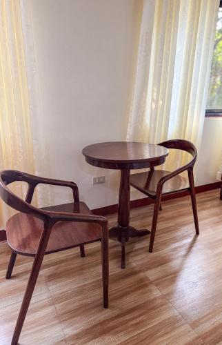 a wooden table and two chairs and a table and chair at Tessie's Home Stay Bed & Breakfast in Puerto Princesa City