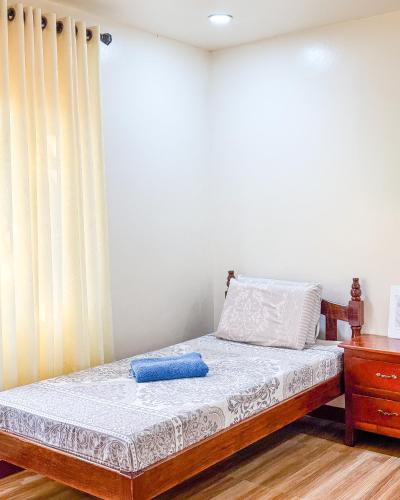 a bedroom with a bed with a blue pillow on it at Tessie's Home Stay Bed & Breakfast in Puerto Princesa City