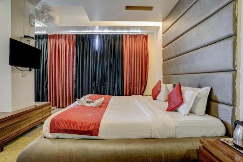 a bedroom with a bed and a flat screen tv at Hotel Shubham Suites in Thane