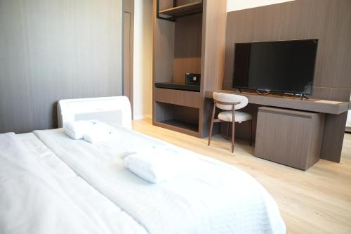 a bedroom with a bed and a desk with a television at Hotel Aquila D in Durrës