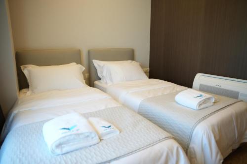 two beds sitting next to each other with towels on them at Hotel Aquila D in Durrës