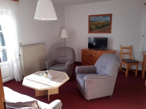 a living room with two chairs and a coffee table at Jägerheim Löbsal in Löbsal