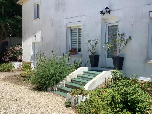 a white house with stairs leading to a door at Autour Des Vignes B&B in Herry