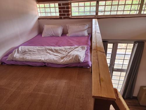 a bedroom with a bed in a loft with windows at The Windsor Villa in Mahirāvani