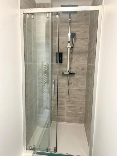 a shower with a glass door in a bathroom at Les suites frontalières T2 avec parking et balcon secteur Thionville Luxembourg in Basse-Yutz