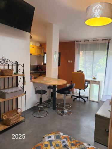 une cuisine avec une table et des chaises dans une pièce dans l'établissement le jardin de MiMi, à Lézignan-Corbières