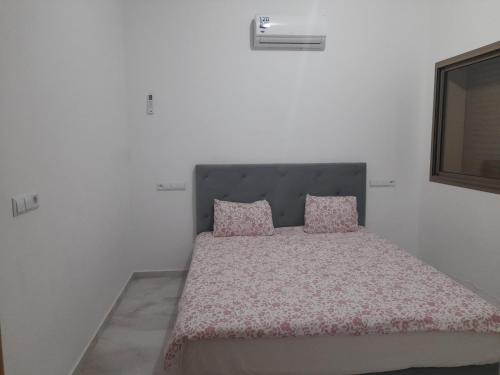 a bedroom with a bed with two pink pillows at Villa Mimouche in Taroudant