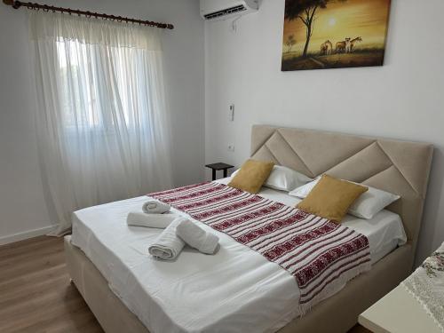 a bedroom with a large bed with towels on it at Apartment Himare Livadhe in Himare