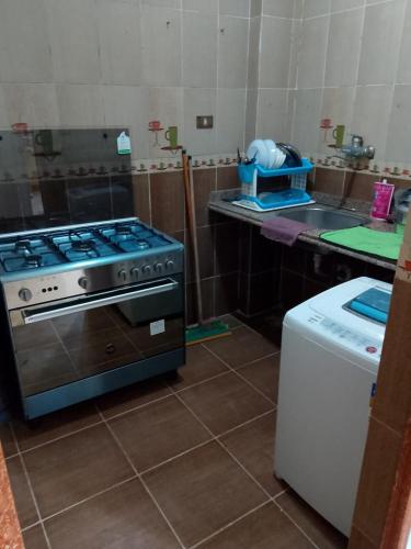 a kitchen with a stove and a counter top at استمتع بالهواء البحري والمناظر الطبيعية Spacious Green View Apartm in Alexandria
