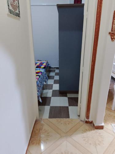 a hallway with a refrigerator and a checkered floor at استمتع بالهواء البحري والمناظر الطبيعية Spacious Green View Apartm in Alexandria
