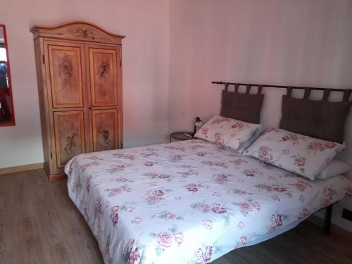 a bedroom with a bed and a wooden cabinet at Le 3 Finestre in Peccioli