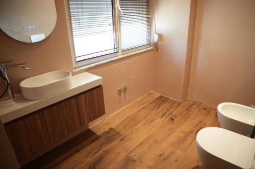 a bathroom with a sink and a toilet and a window at Hotel Aquila D in Durrës