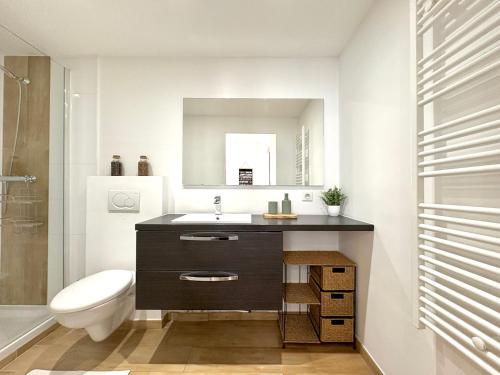 a bathroom with a sink and a toilet and a mirror at Appartements climatisés - Vieil Antibes in Antibes