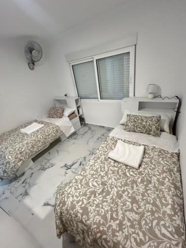 a bedroom with two beds and a window at Luxury flat Mar de Cristal in Mar de Cristal