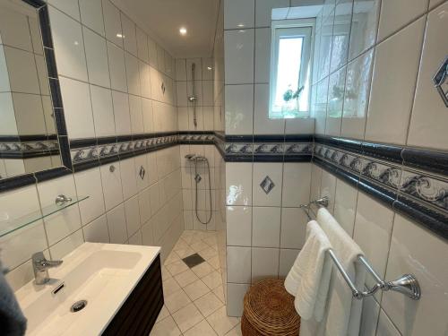 a white bathroom with a sink and a mirror at Charming central penthouse with big terrace in Oslo