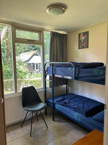 a bedroom with two bunk beds and a chair at Huisje 118 bungalowpark Simpelveld in Simpelveld