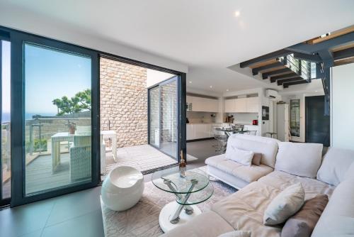 un salon avec un canapé blanc et une table dans l'établissement Duplex - Terrasse vue mer & Jacuzzi - Parking - DU, à Èze