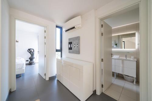 une salle de bain blanche avec un lavabo et un miroir dans l'établissement Duplex - Terrasse vue mer & Jacuzzi - Parking - DU, à Èze
