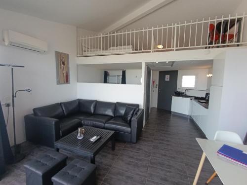 un salon avec un canapé et une table dans l'établissement AS14629 - P2 Mezzanine avec vue mer latérale, dans une résidence sur plage avec parking privé, au Grau-du-Roi