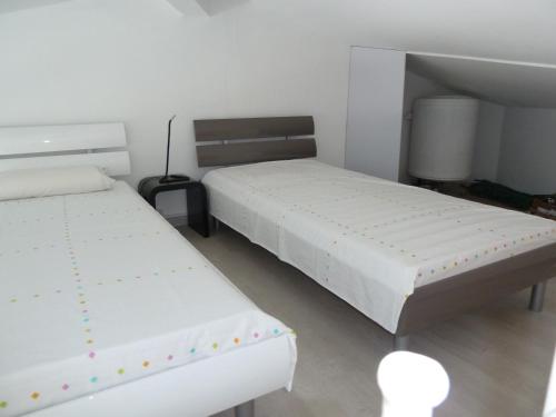 une chambre avec deux lits et un miroir dans l'établissement AS14629 - P2 Mezzanine avec vue mer latérale, dans une résidence sur plage avec parking privé, au Grau-du-Roi