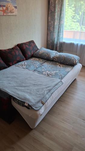 Una cama sentada en una habitación con ventana. en Mazais Ligzdiņš, en Ventspils