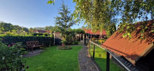 a garden with an orange roof and a bench at de Schure in Elim