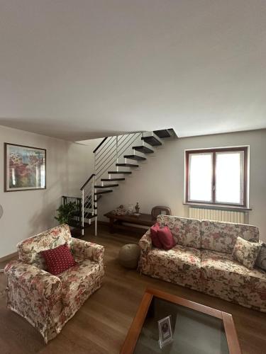 a living room with two couches and a staircase at Civico60 in Solbiate Arno