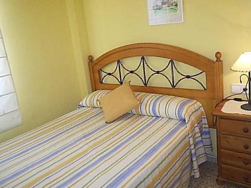 ein Schlafzimmer mit einem Bett und einem Kissen darauf in der Unterkunft Apartamento con vistas al mar in Piles