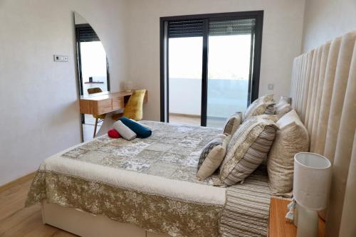 a bedroom with a large bed with pillows on it at Zen garden by sea in Aïn Harrouda