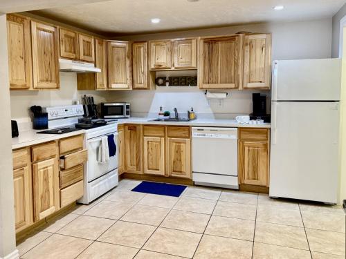 a kitchen with white appliances and wooden cabinets at Charming Provo Home close to BYU and Utah Lake in Provo