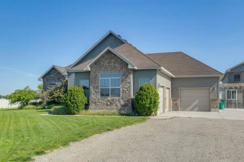 a house with a driveway and a garage at Rigby Gem with Hot Tub Theater Game Room Grill in Rigby