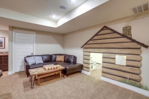 a living room with a leather couch and a play house at Rigby Gem with Hot Tub Theater Game Room Grill in Rigby