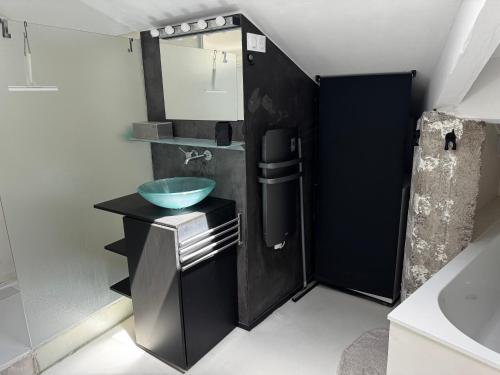 La salle de bains est pourvue d'un lavabo et d'une armoire noire. dans l'établissement La manufacture, à Antraigues-sur-Volane
