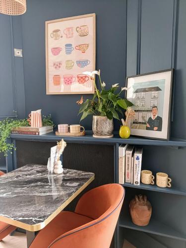 a dining room with a table and orange chairs at Hotel Les Chambres de L'Opaline in Binic-Etables-sur-Mer
