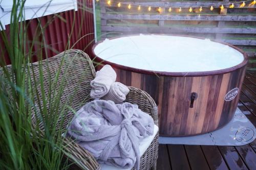 a wicker chair sitting next to a bath tub at Entire house with hot tub and beachfront in Köping