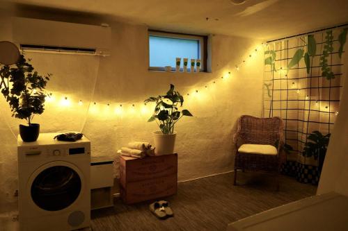 a laundry room with a washing machine and a chair at Entire house with hot tub and beachfront in Köping