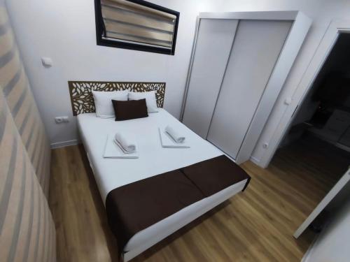ein Schlafzimmer mit einem Bett mit weißer Bettwäsche und einem Fenster in der Unterkunft MILUX in Sanski most
