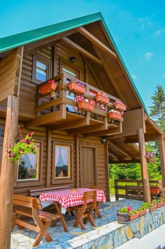 a log cabin with a table and a balcony at Mountain Viewpoint in Žabljak