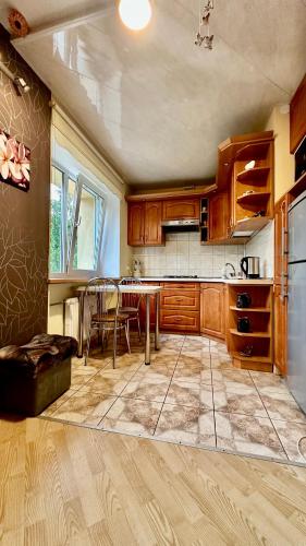 a kitchen with wooden cabinets and a table with chairs at NeriesApartment No.1 Holidays By J. Basanaviciaus in Palanga