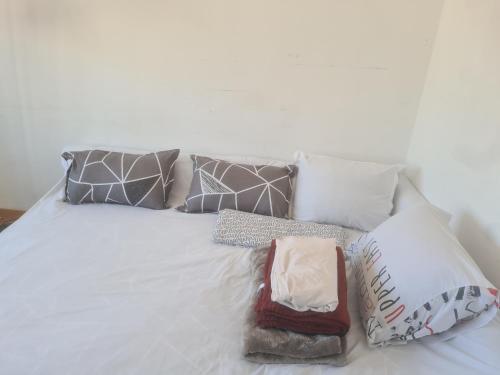 a white bed with several pillows on it at QuickHosting Bordeaux Centre in Bordeaux
