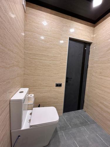 a bathroom with a toilet and a black door at Comfortable appartment in historical Ashtarak in Ashtarak