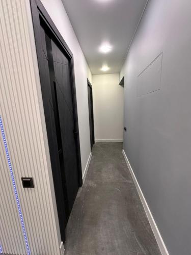 a hallway with black doors and concrete floors at Comfortable appartment in historical Ashtarak in Ashtarak