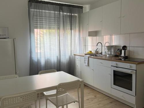 a kitchen with white cabinets and a table and chairs at Ferienwohnung Rheinglück in Oppenheim