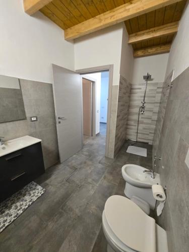a bathroom with two toilets and a sink at Le Dune di Quarzo in Càbras